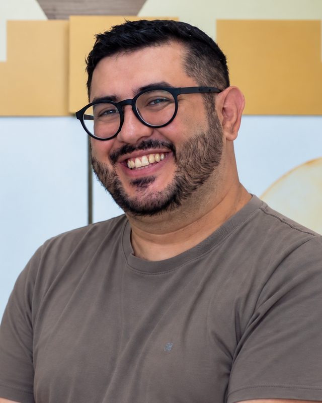Luiz Henrique de Oliveira sorrindo, de óculos e camiseta
